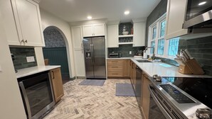 A modern kitchen with a refrigerator, microwave, oven, and stove.