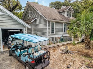 A residential property with a garage, a golf cart, and a wooden deck.