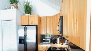 Une cuisine moderne avec des meubles en bois, des appareils en acier inoxydable et un four encastré.