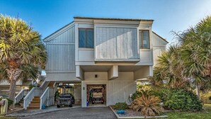 Une maison à deux étages avec un garage fermé, un escalier et un véhicule garé à l’intérieur.