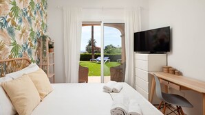 Een hotelkamer met een bed, een bureau, een televisie en uitzicht op de omgeving.