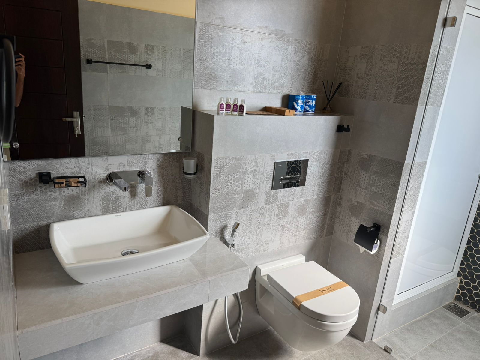 Un baño moderno con un lavamanos grande de color blanco, un inodoro y una zona de ducha.