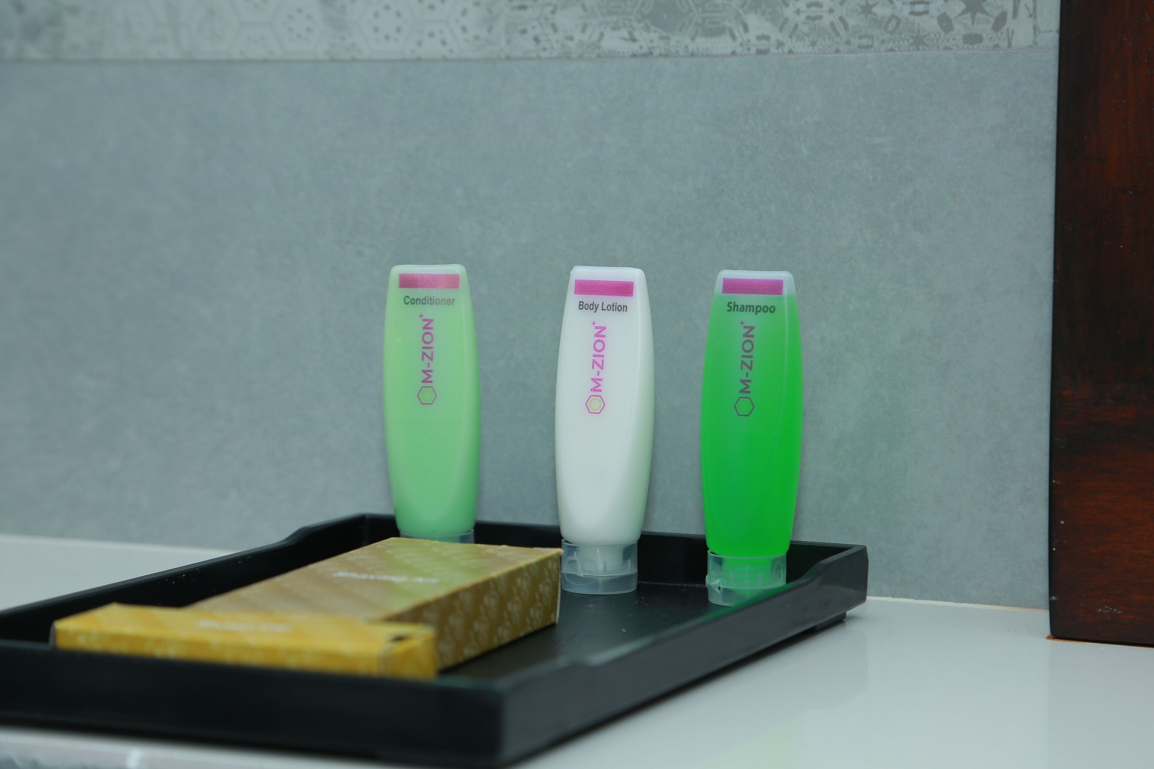 Three M-ZION personal care products on a black tray.