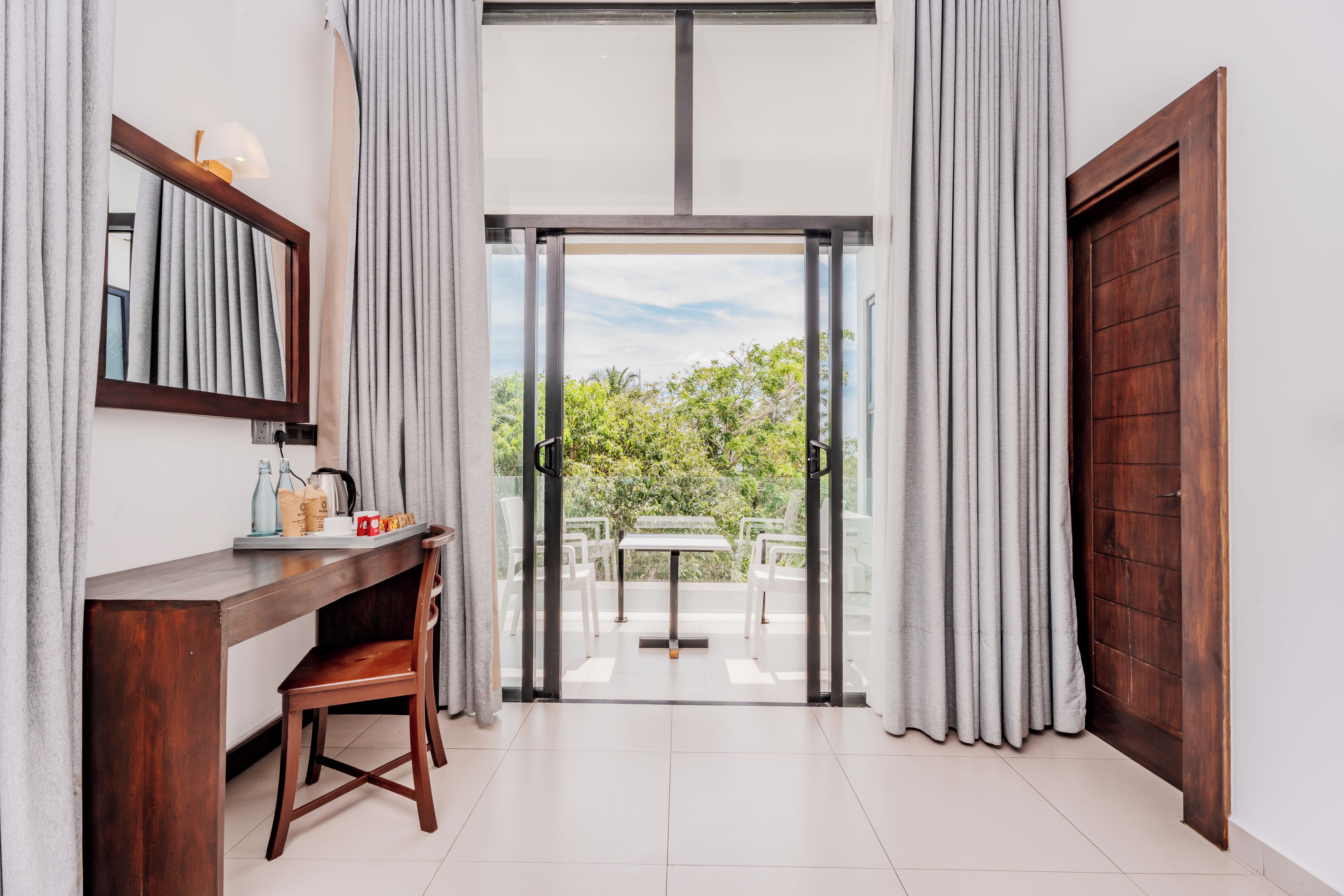 Habitación moderna con un escritorio de madera, una silla, una mesa y vistas a zonas verdes.