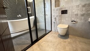 A modern bathroom with a glass-enclosed shower, a white toilet, and a freestanding bathtub. - Mzion Hotel Weligama (Weligama)