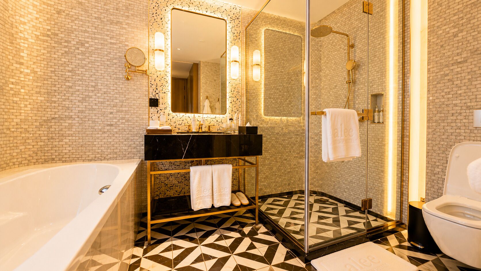 A modern bathroom with a bathtub, a shower, and a toilet.