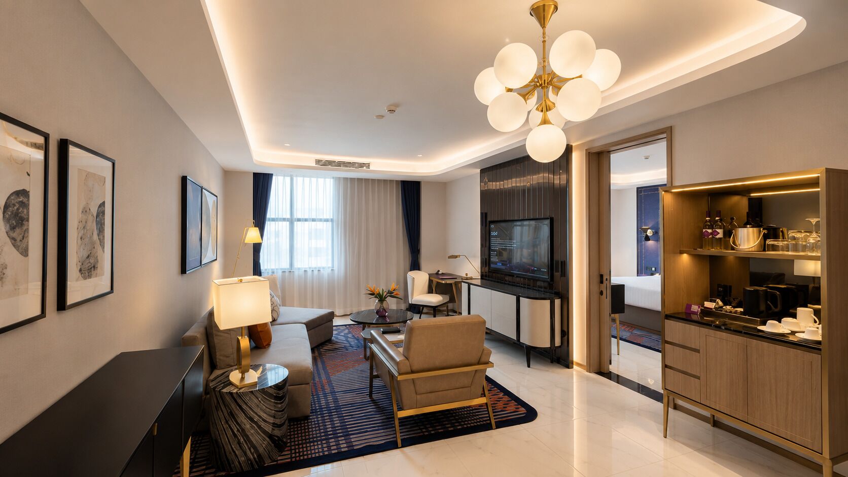 A modern hotel room with a living area, a dining area, and a kitchenette.
