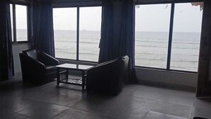 A room with a large window, two chairs, and a small table. - White Seasons Resort And Spa (Malvan)