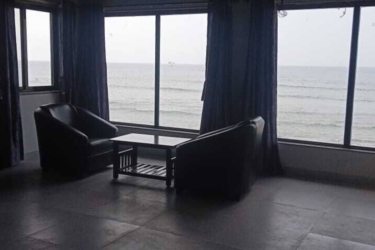 A room with a large window, two chairs, and a small table.