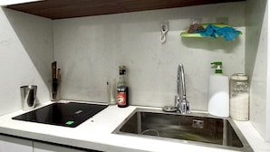 A kitchen with two sinks, a knife block, a bottle of liquid, a soap dispenser, and a spice rack. - Amelie Homestay (Hanoi)