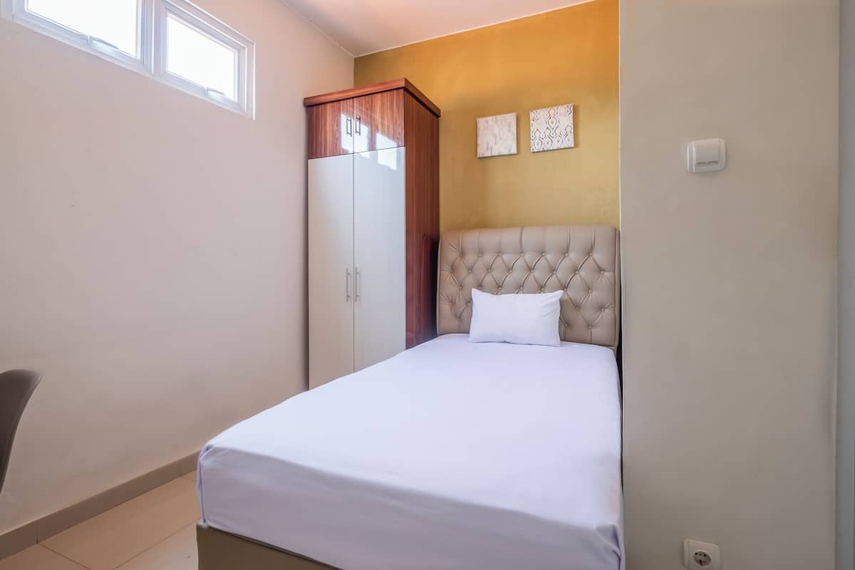 Ein Schlafzimmer mit einem Bett, einem Kleiderschrank und zwei an der Wand befestigten Kunstwerken.
