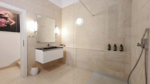 Uma casa de banho moderna com toucador branco, um espelho grande, cabine de duche com porta de vidro e prateleira com artigos de higiene pessoal.