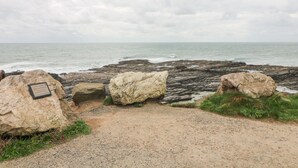 A rocky coastal path leading to the sea with a plaque on a large rock. - Old Field House (Templetown)
