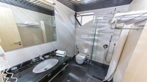 A modern bathroom with a marble sink, a toilet, and a glass-enclosed shower area. - Hotel Brilant (Sarandë)