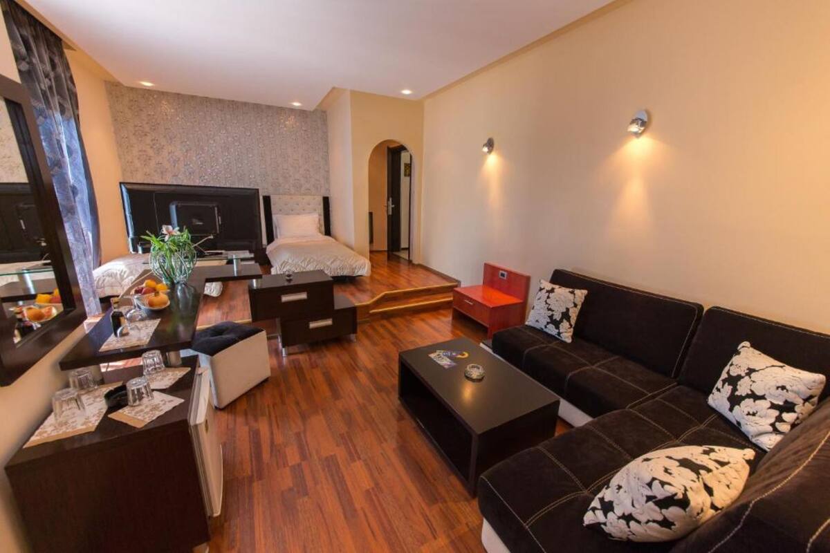 Una sala de estar moderna con sofá, mesa de centro, televisor y chimenea.