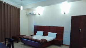 A hotel room with a bed, a wardrobe, a desk, and a chair. - Blue Star Apartments (Entebbe)
