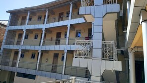 A multi-story building with balconies, railings, and a fire extinguisher. - Blue Star Apartments (Entebbe)
