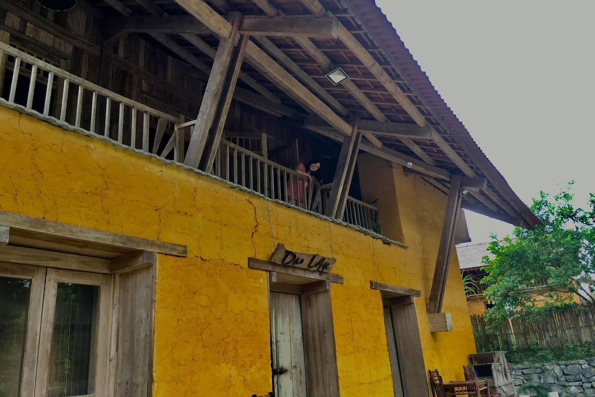 Un bâtiment jaune doté d’un balcon et d’une enseigne sur laquelle on peut lire « De Loco ».