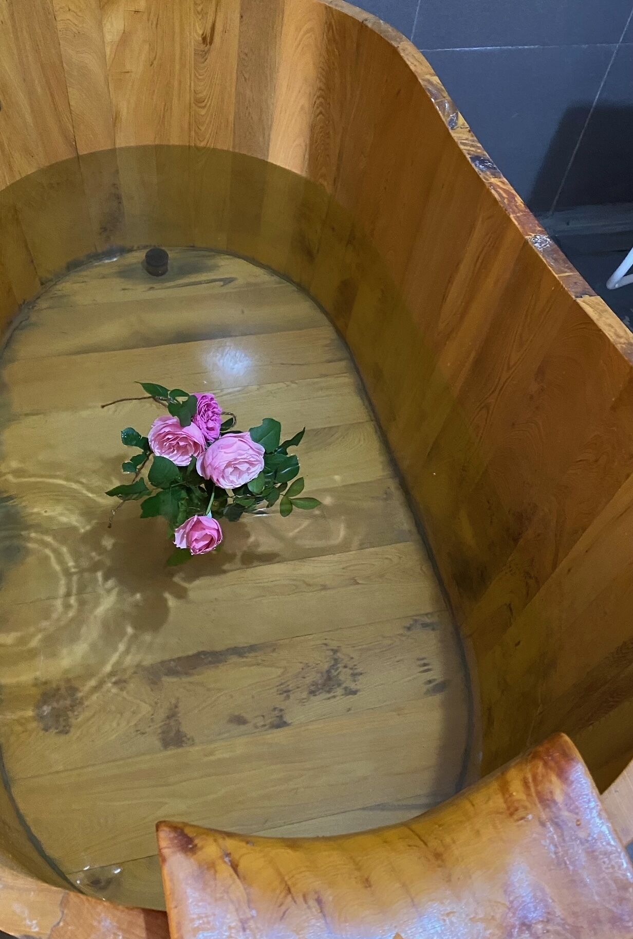 Una bañera de madera con un arreglo floral.