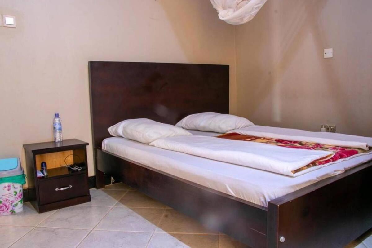 Quarto com cama, mesa de cabeceira e uma pequena mesa.
