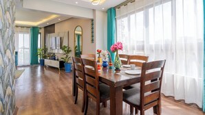 A dining area with a wooden table, chairs, and a vase of flowers.
