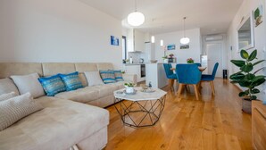 Uma sala de estar moderna com sofá, mesa de centro e área de jantar com cadeiras.