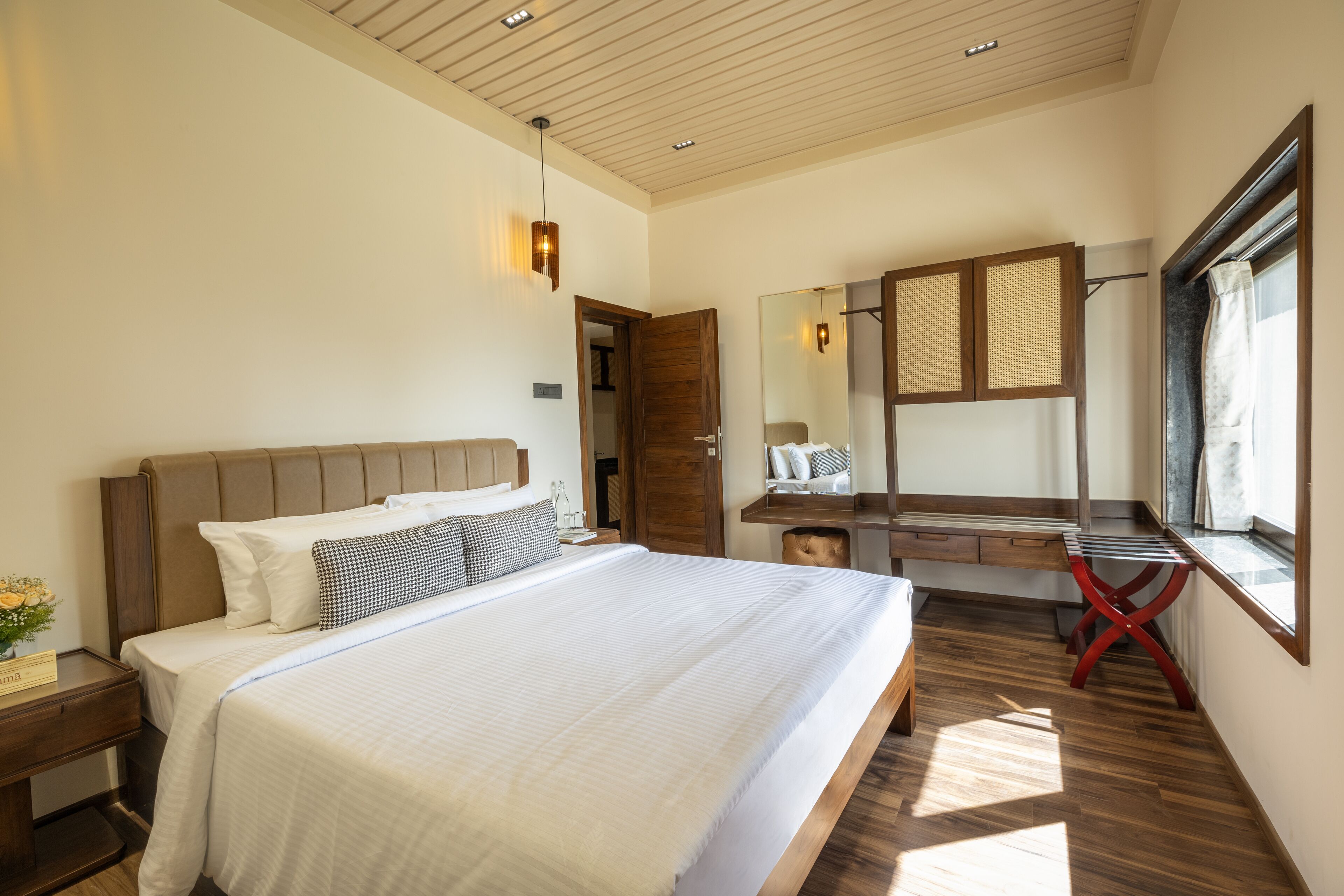 Une chambre moderne avec un grand lit, un bureau en bois et un miroir.