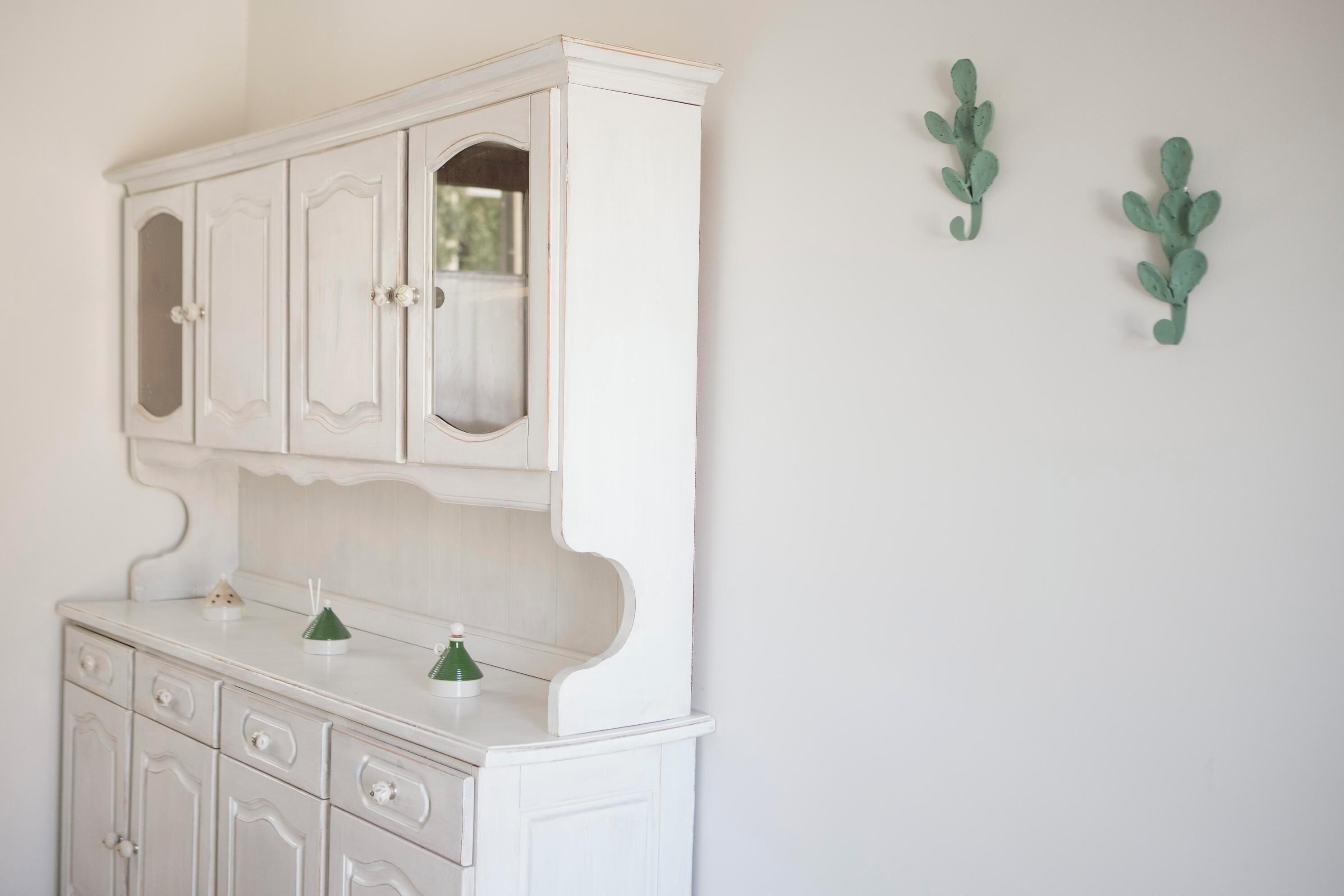 A white cabinet with multiple drawers and a mirror.