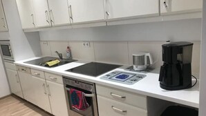 Una cocina moderna con horno integrado, cafetera y lavavajillas.
