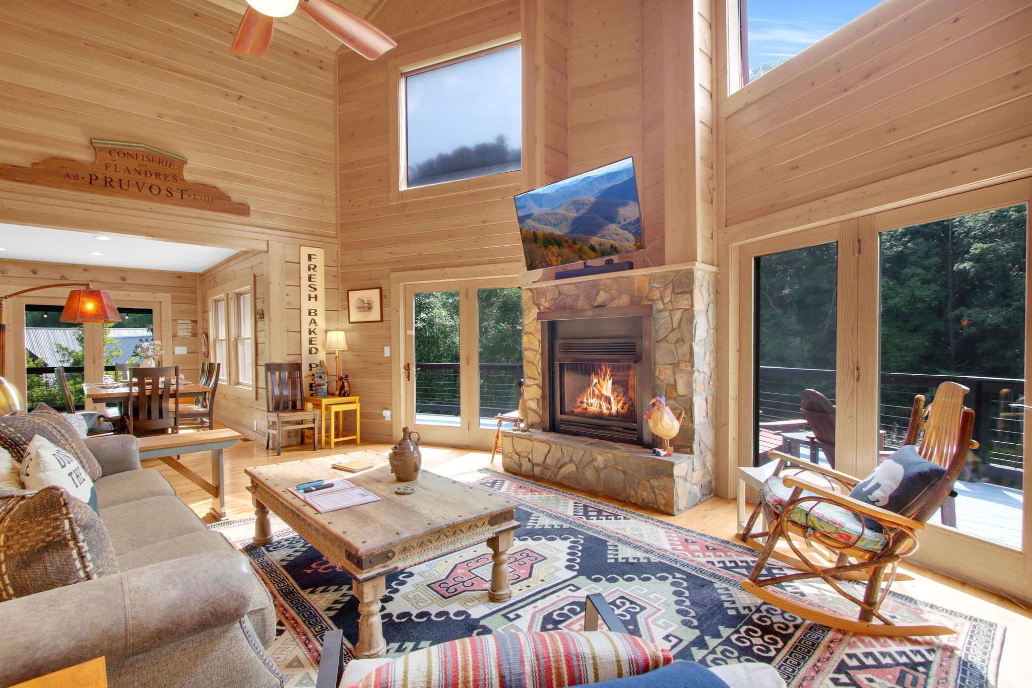 A spacious living room with a fireplace, large windows, and a cozy seating area.
