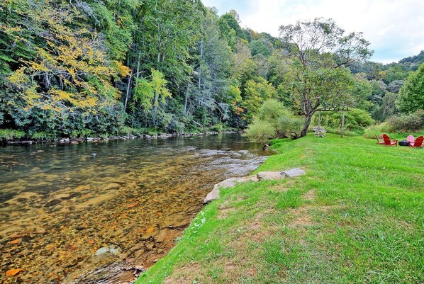 A river with clear water, surrounded by lush greenery and trees.