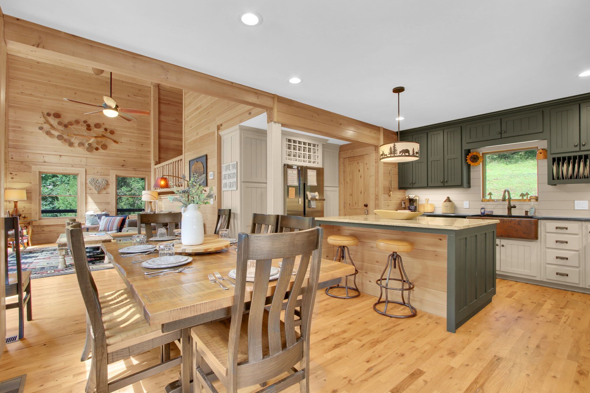 A spacious kitchen with wooden cabinetry, a central island, and a dining area with a wooden table and chairs.
