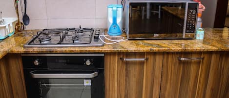 Deluxe Apartment | Private kitchen | Fridge, microwave, cookware/dishes/utensils, dining tables