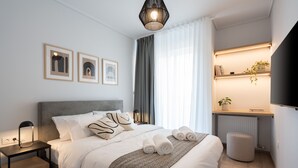 Una habitación de hotel moderna con una cama bien hecha, lámparas de noche, una mesita, un radiador y un estante con una planta.