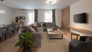 Una sala de estar moderna con sofá, mesa de centro y comedor.