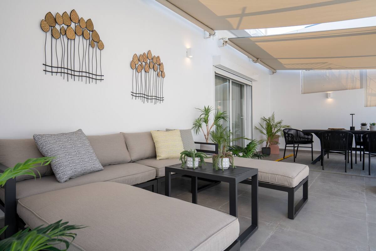 Uma sala de estar moderna com sofá, mesa de centro e plantas em vasos.