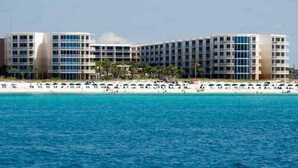A hotel with multiple floors, a beach in the background, and a clear blue sky. - Waterscape 1 bedroom w bunks A side walkout -beach (Ft Walton Beach)