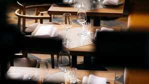 A restaurant with tables set for dining, each with a menu, a glass, and a napkin. - Hotel Kint (Valkenburg aan de Geul)