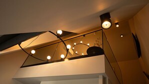 A modern interior with a geometric ceiling design and recessed lighting. - Hotel Kint (Valkenburg aan de Geul)