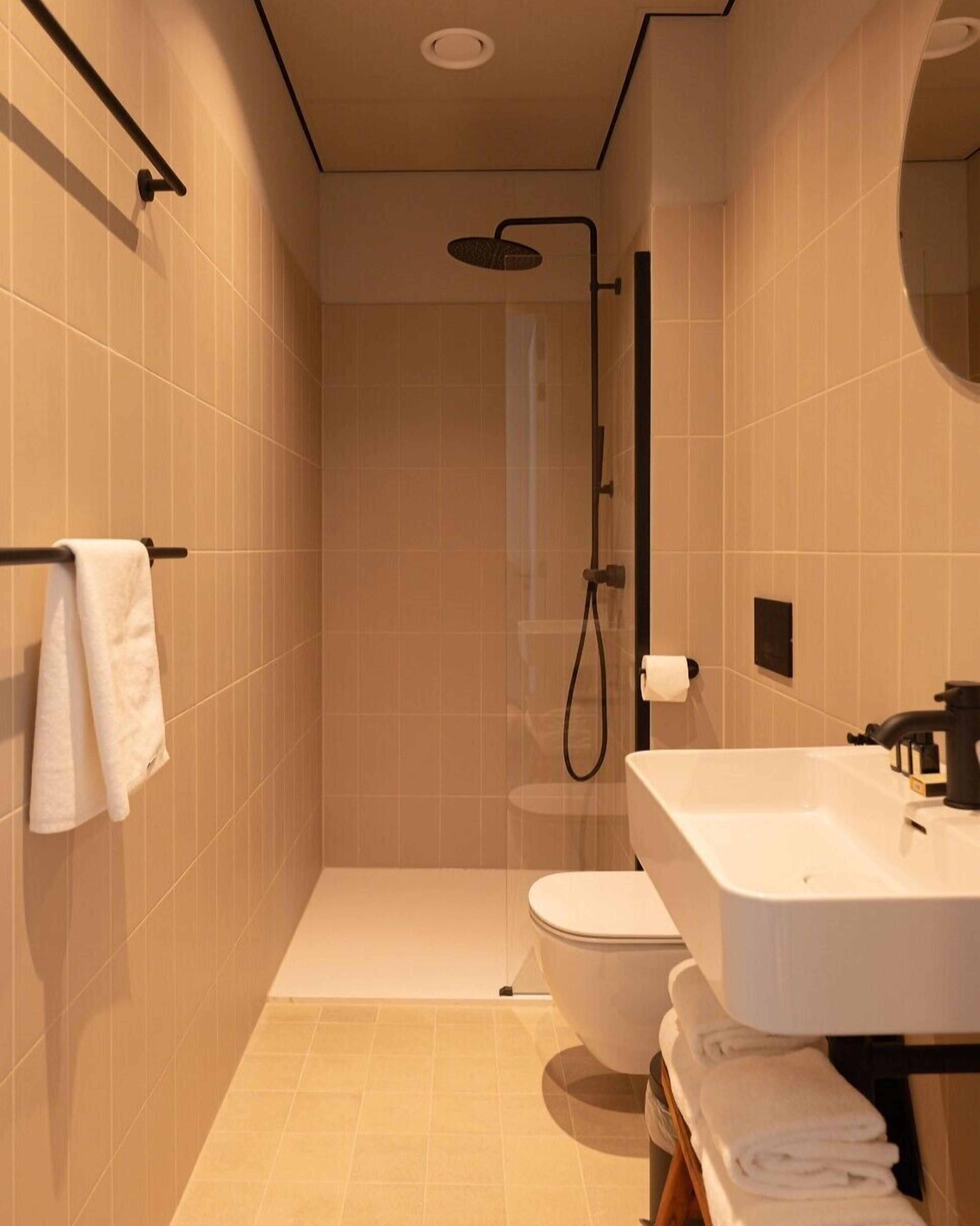 Une salle de bain moderne équipée d’une douche, de toilettes et d’un lavabo.