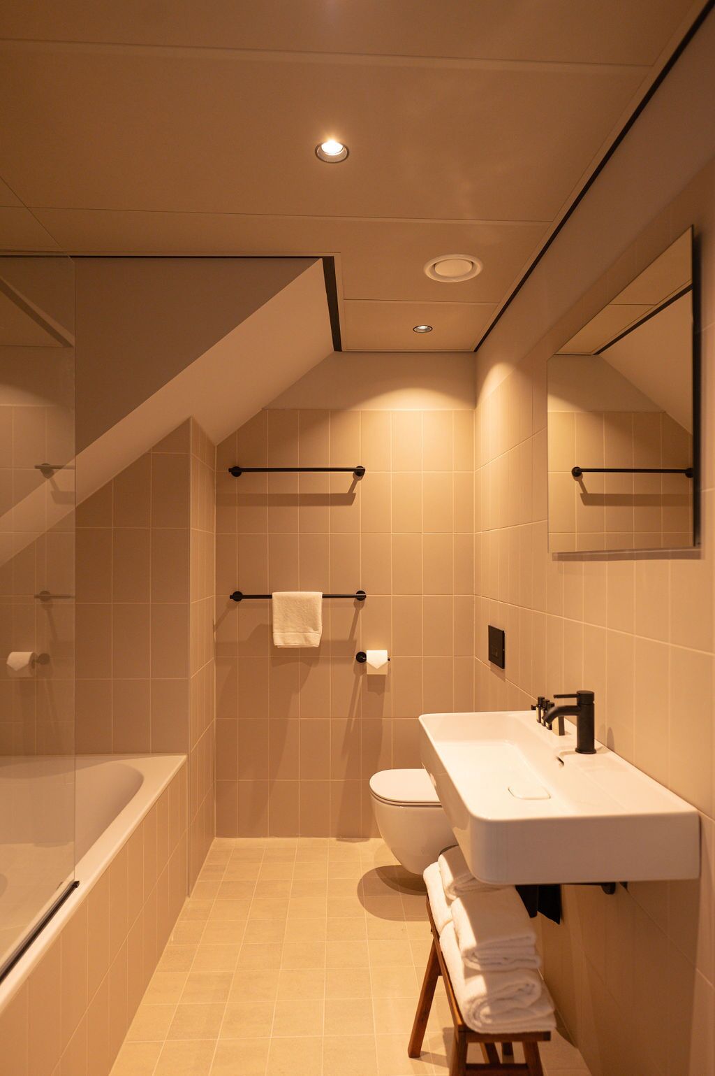 A modern bathroom with a bathtub, toilet, and sink.