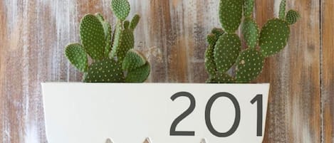 A white planter with the number 201 on a rustic wooden background.