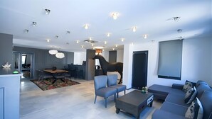A modern living room with a sofa, chairs, a coffee table, and a TV. - Smart City Suites Bodrum (Bodrum)