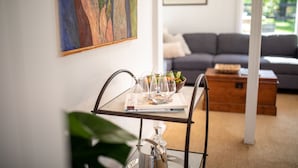 Un coin repas avec un chariot en métal, une table et un canapé en arrière-plan.