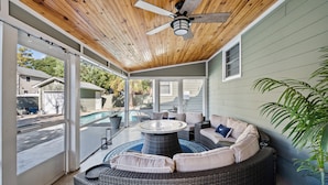 A covered patio with wicker furniture, a ceiling fan, and a view of a swimming pool and neighboring houses. - Pet Friendly Private House w/Pool & Game Room + Free Attraction Tickets! (North Myrtle Beach)