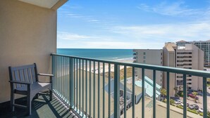 Ein Balkon mit Blick auf das Meer und Gebäude.