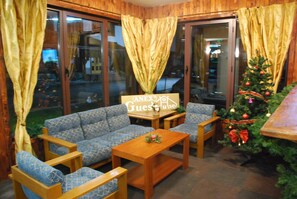 A cozy room with a sofa, wooden coffee table, and a Christmas tree.