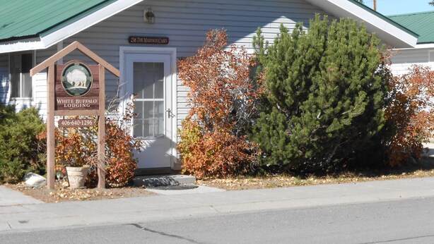 A lodge with a green roof, a signboard with a buffalo emblem, and a number 236 on the building.