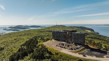 Un edificio moderno con estacionamiento y vista al mar.