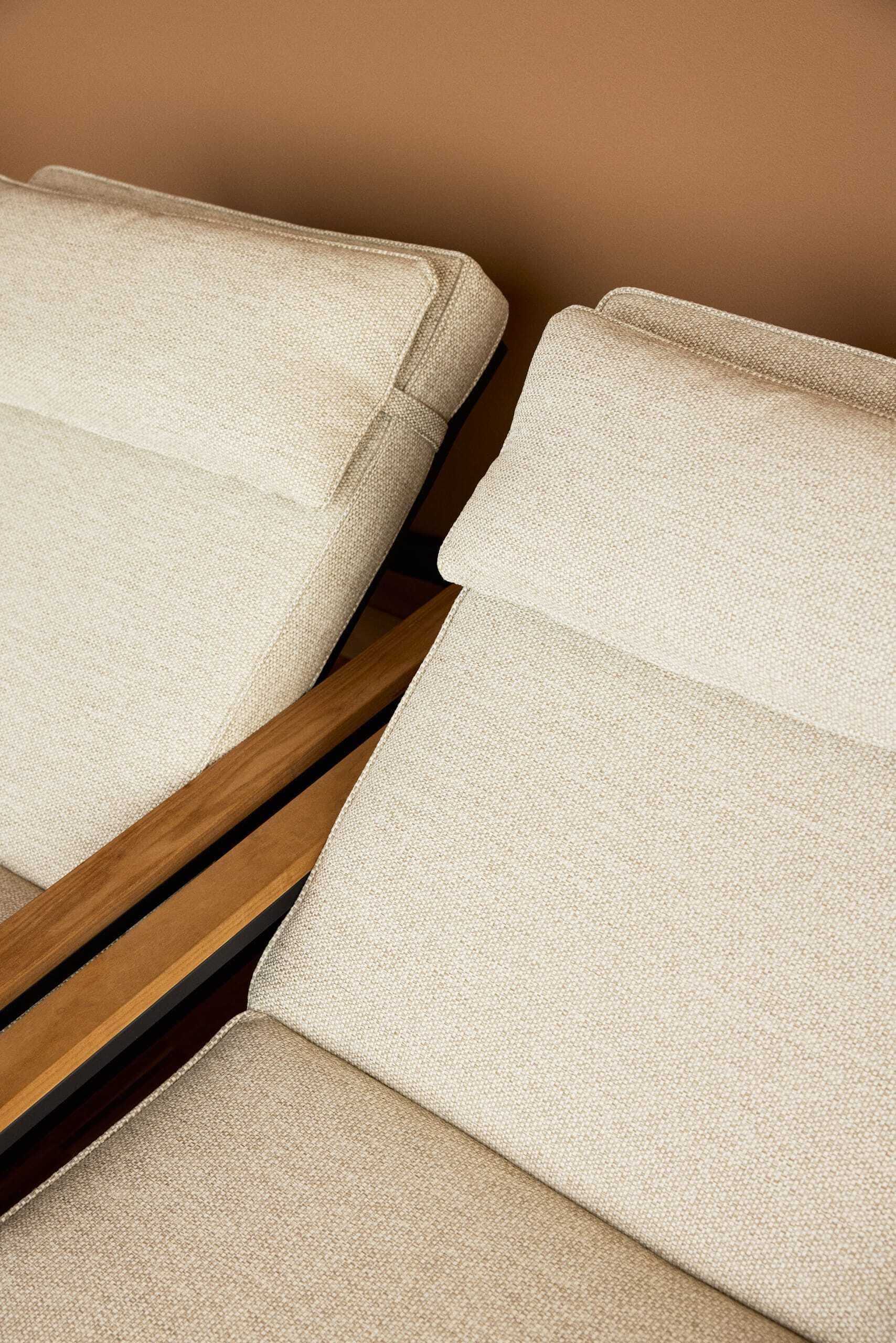 A close-up of a sofa with a textured fabric and wooden frame.